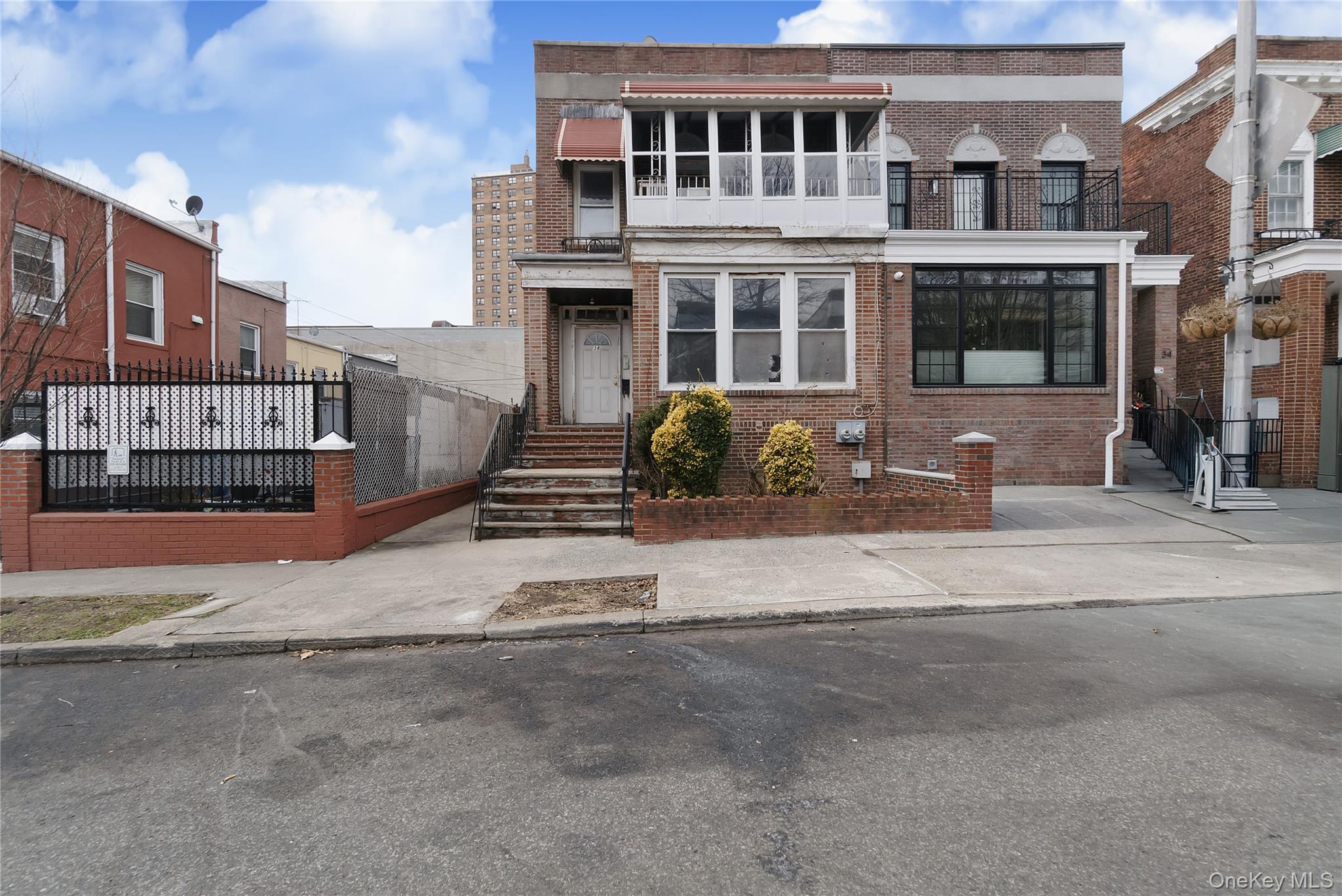 View of front of property featuring brick siding and a balcony