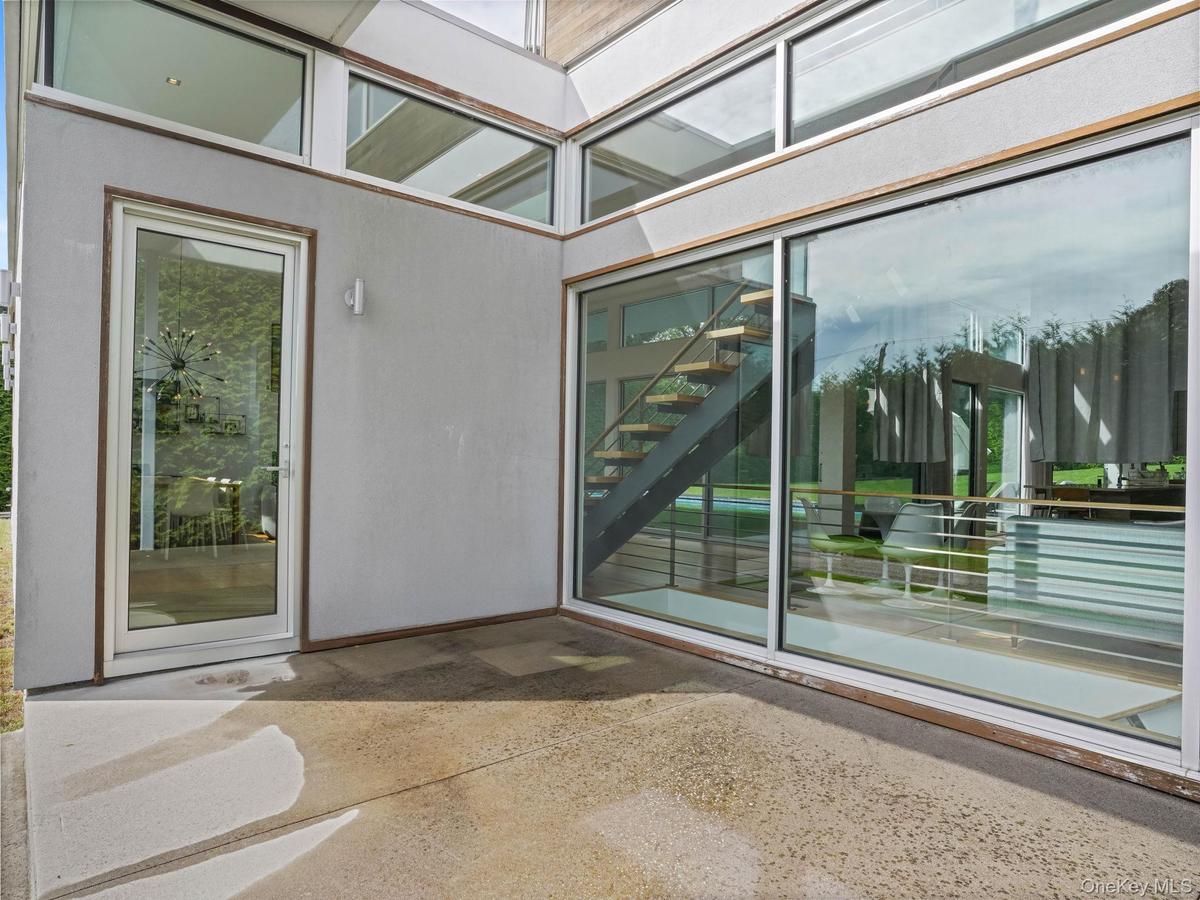 Entrance to property with stucco siding and a patio area