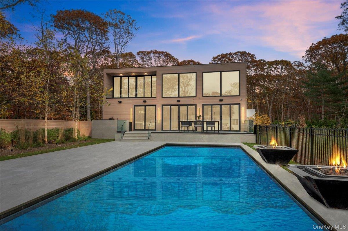 Back of house at dusk featuring a patio area and a fire pit