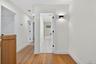 Hallway with hardwood floors and sconce for accent lighting