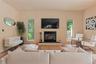 Living room featuring a glass covered fireplace, plenty of natural light, and wood finished floors