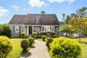 Cape cod house with a front lawn and a chimney