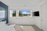 Bedroom with concrete floors and multiple windows