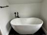Bathroom with tile patterned floors, baseboards, and a freestanding bath