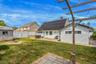 Back of property with a hot tub, solar panels, a patio area, a chimney, and a fenced backyard
