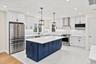 Bright formal dining area and kitchen transition layout, featuring premium quartz counters and open space with optional builder customization for arch