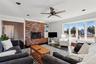 Living room featuring ornamental molding, a brick fireplace, wood-type flooring, and built in features