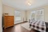 Bedroom featuring hardwood / wood-style flooring, radiator, multiple windows, and ornamental molding