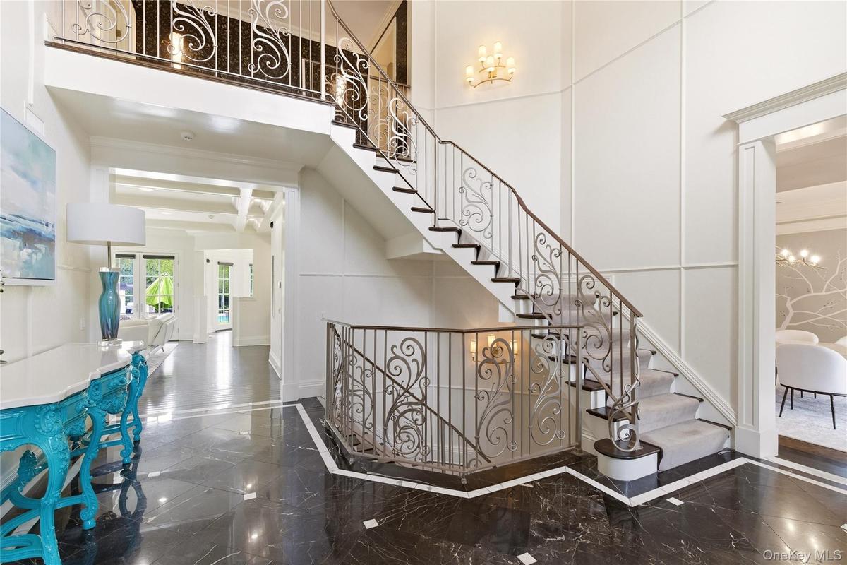 Dramatic Two Story Foyer | Wrought Iron Railing | Marble Foyer | Detailed Millwork