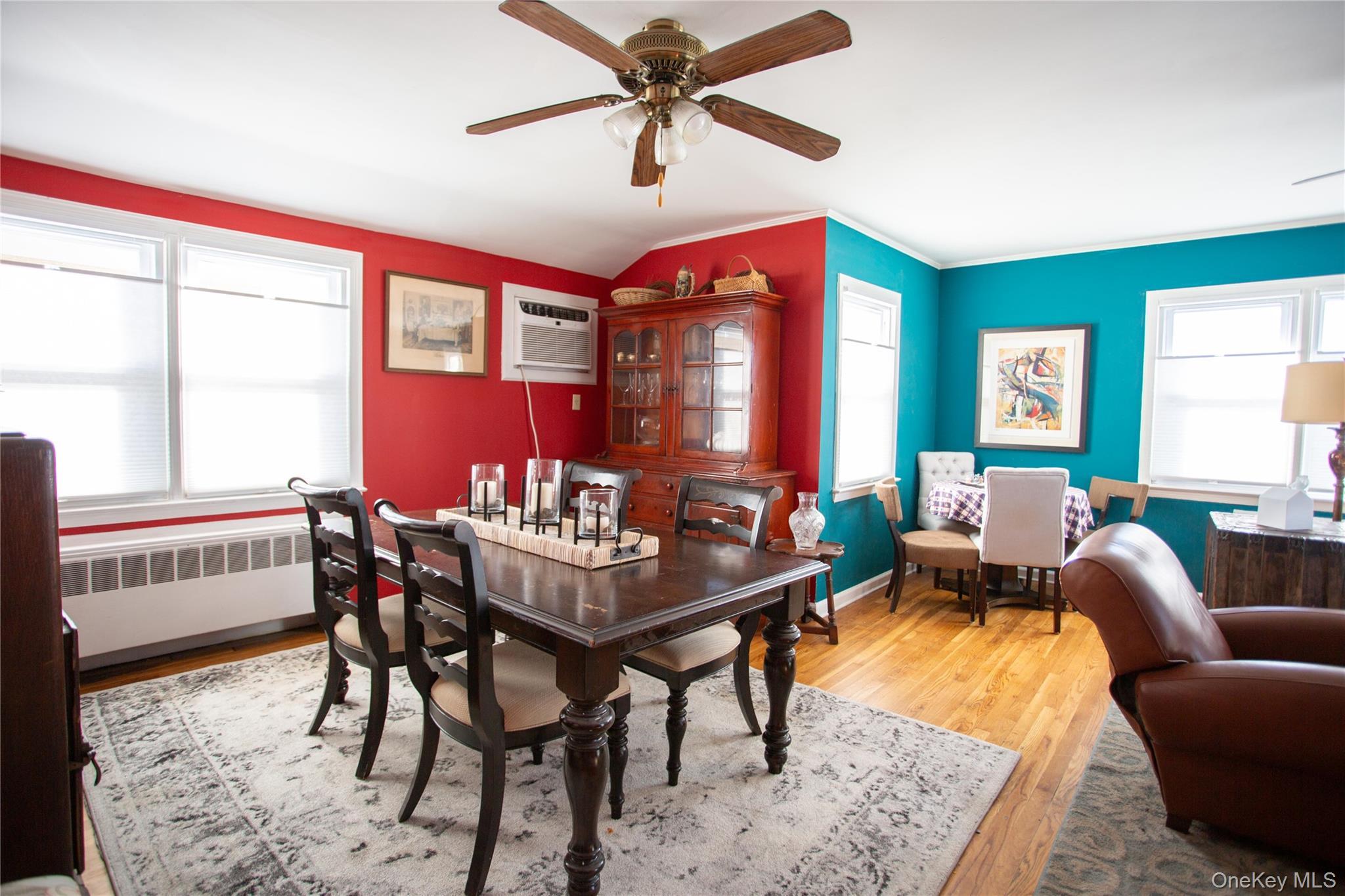 Dining room with light wood-type flooring, radiator heating unit, healthy amount of natural light, ceiling fan, and crown molding