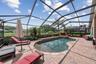 Custom screened pool with pavered deck and water views.