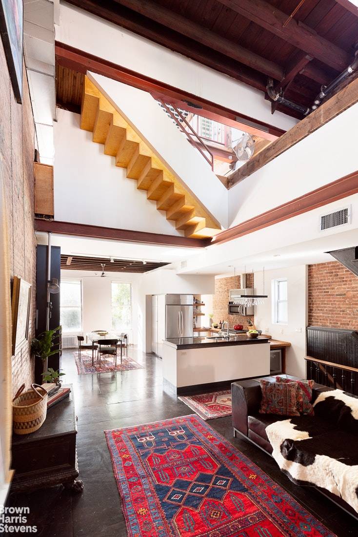 This soaring industrial chic two family townhome was designed by the architect owner to embrace Red Hook's rough hewn history by incorporating repurposed salvaged beams, exposed brick, and structural steel.
