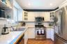Kitchen featuring appliances with stainless steel finishes, white cabinets, glass insert cabinets, backsplash, and recessed lighting