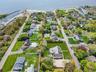 Expansive property just 5 houses from the Great South Bay featuring a sizable residential structure, extensive green lawn, and gravel driveway