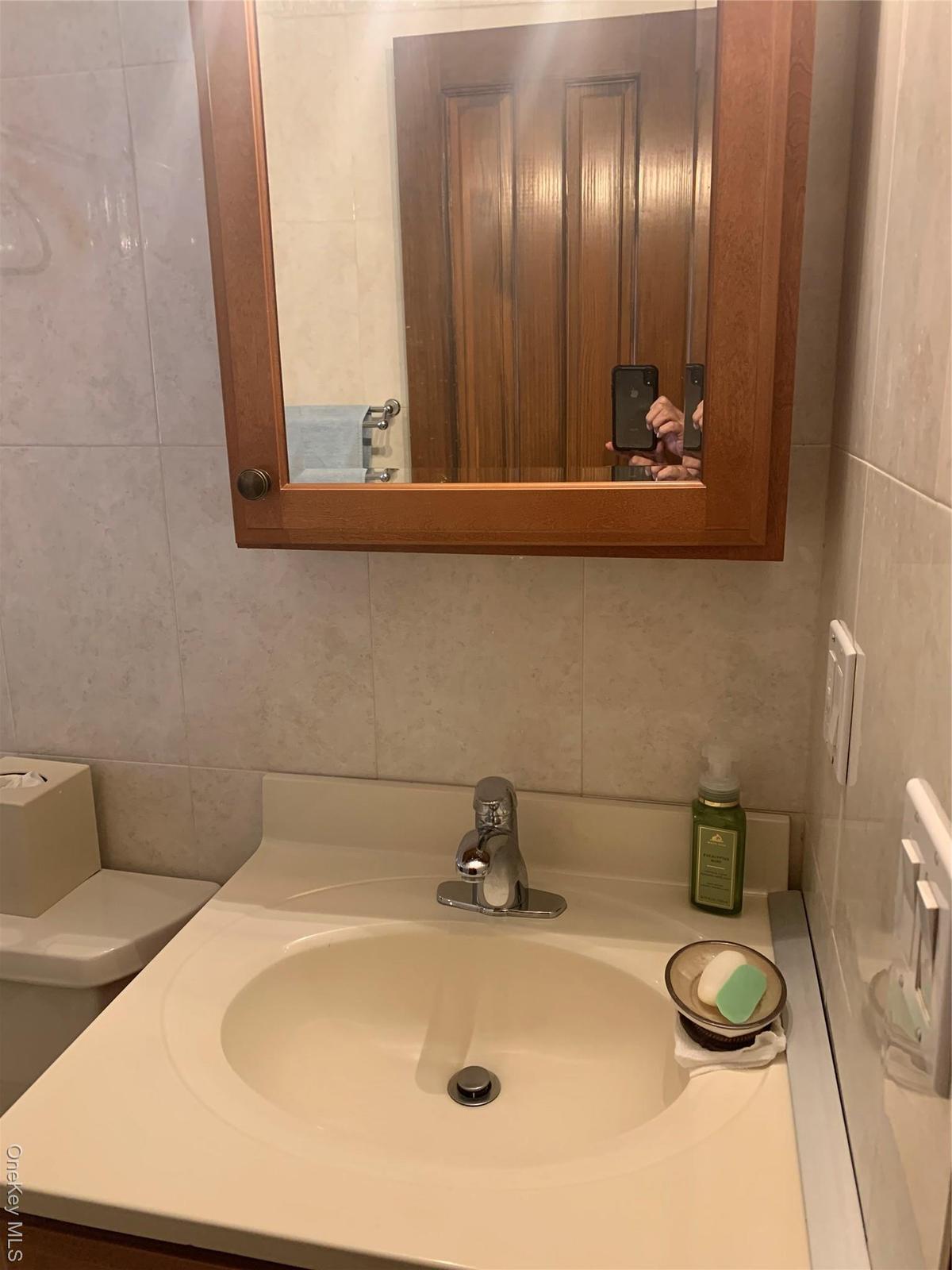 Bathroom featuring vanity and tile walls