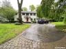 Colonial inspired home featuring asphalt driveway and a front yard