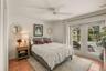 Guest bedroom with private access to the screened lanai and pool area through sliding glass doors