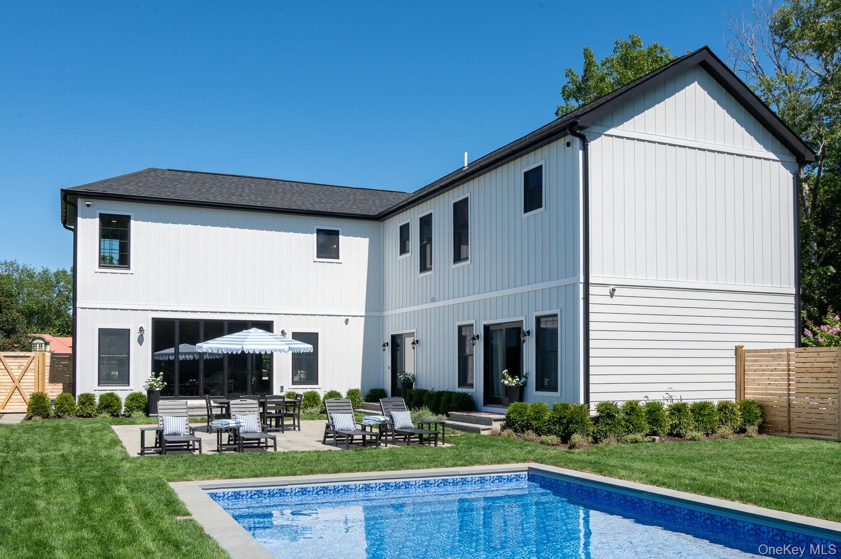 Back of property with a patio area, an outdoor pool, and a incredible sun.