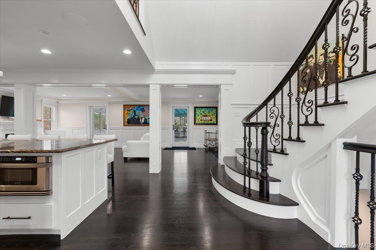 Entrance foyer featuring a decorative wall, dark wood-type flooring, wainscoting, crown molding, and recessed lighting