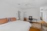 Bedroom featuring light wood finished floors, a desk, and ceiling fan