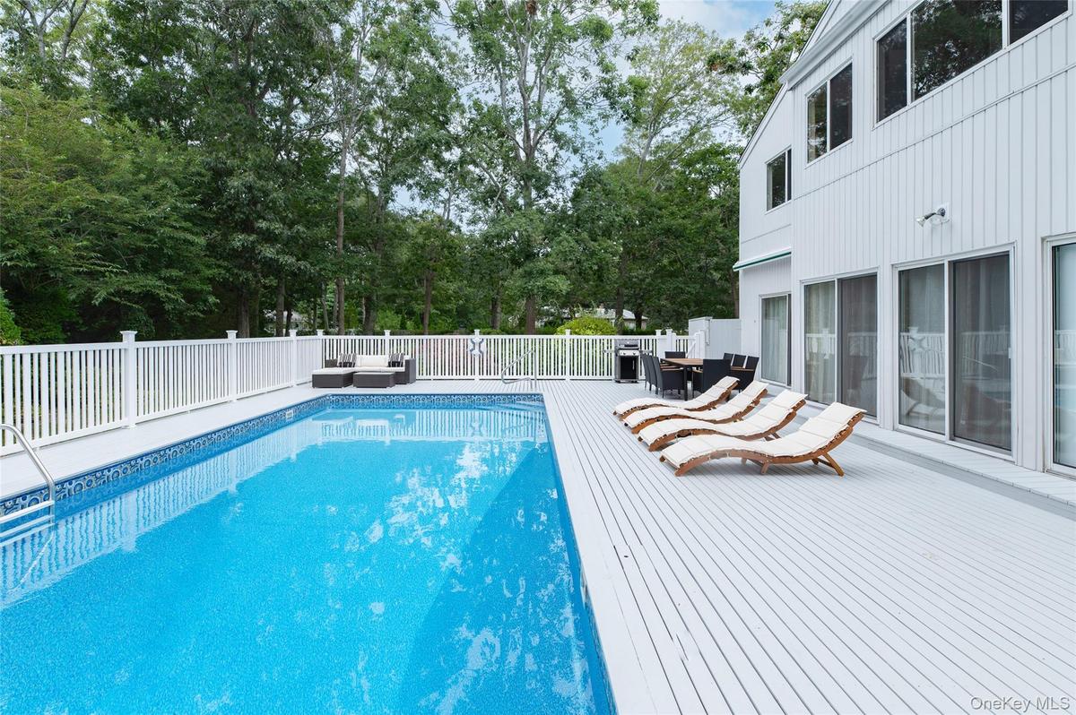 View of swimming pool featuring outdoor dining space, a wooden deck, and an outdoor hangout area