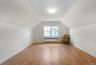 Bonus room with radiator heating unit, light wood finished floors, and lofted ceiling