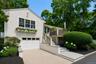 Coastal home with water view, garage, windows with box planters, spacious deck and yard