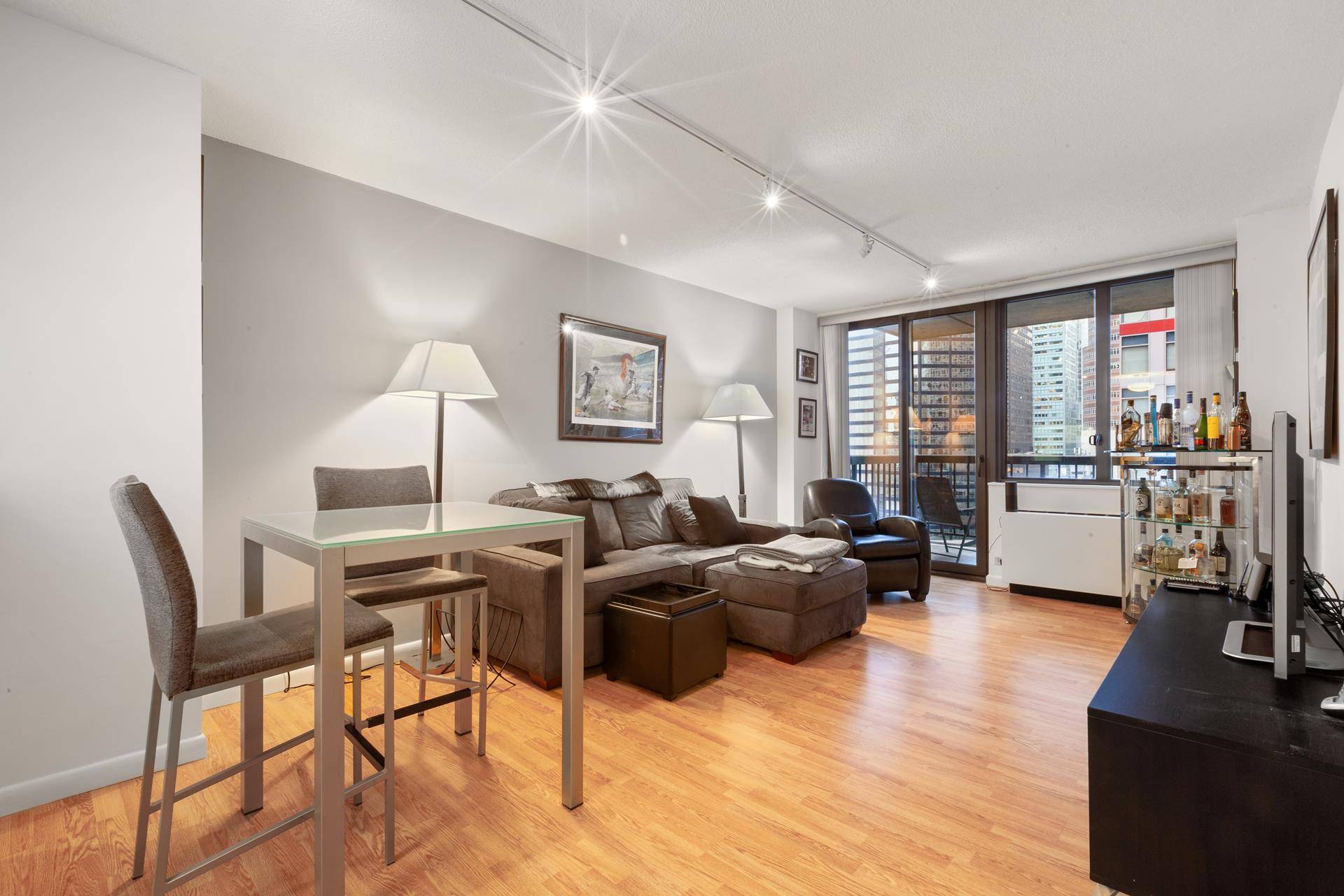 Spacious one bedroom apartment with a private balcony overlooking the city on the 16th floor of a full service co op in Midtown East.