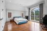 Bedroom featuring access to outside, wood finished floors, recessed lighting, and vaulted ceiling