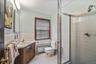 Bathroom with vanity, radiator, light tile patterned flooring, a stall shower, and a wainscoted wall