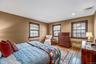 Bedroom featuring radiator heating unit, wood-type flooring, and recessed lighting