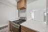 Kitchen with new appliances, neutral cabinetry and quartz counter tops
