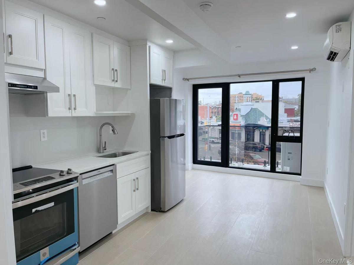 Kitchen with appliances with stainless steel finishes, white cabinets, recessed lighting, light stone countertops, and a wall mounted AC
