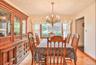 Dining space with light wood-style floors, a chandelier, and a textured ceiling