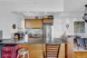 Kitchen with a peninsula, a toaster, stainless steel appliances, decorative backsplash, and dark countertops