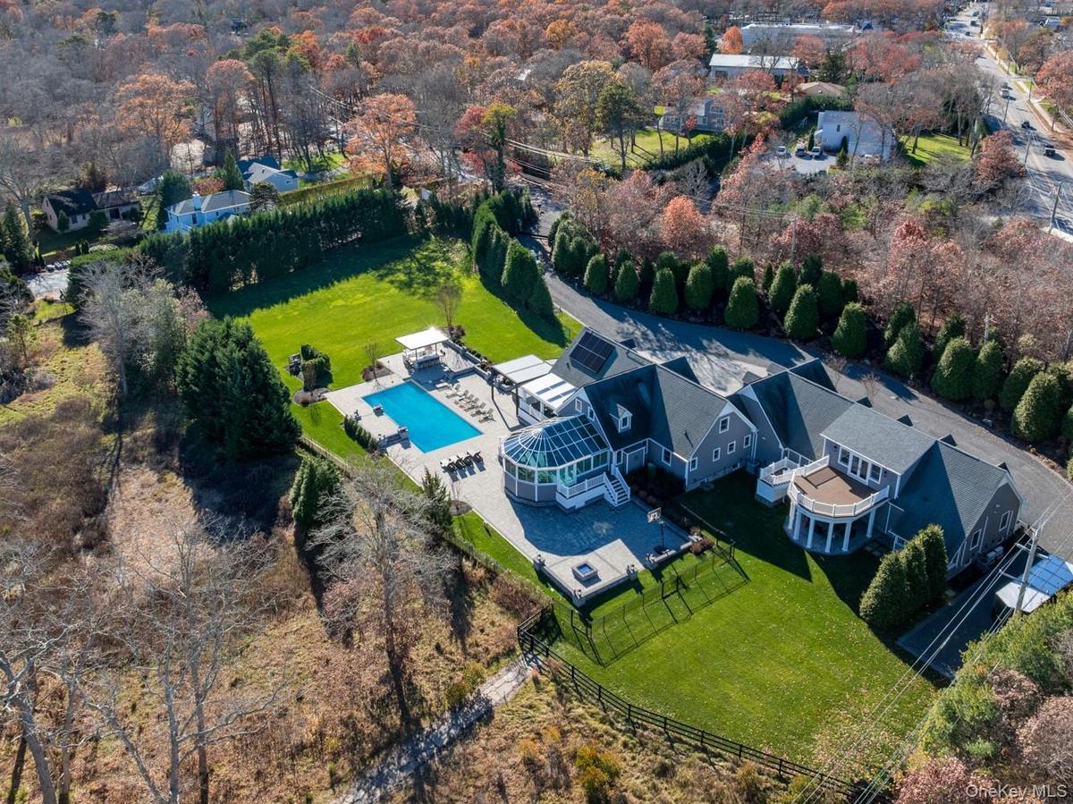 Bird's eye view of a pool area and a tree filled landscape
