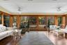 Sunroom with plenty of natural light, wood finished floors, and view of wooded area