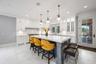 Kitchen featuring crown molding, backsplash, light countertops, a kitchen bar, and a kitchen island with sink