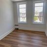 Unfurnished room with dark wood-type flooring and radiator heating unit