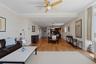 Expansive open-concept living area featuring wood-finish flooring, a ceiling fan, recessed lighting, and crown molding