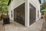 Exterior view showcasing the screened lanai, paver patio, and low-maintenance outdoor living space.