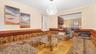 Living room with wood-type flooring, crown molding, a wainscoted wall, and a chandelier