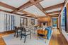 Living room with light wood-oak flooring, a fireplace, coffered ceiling, and suspended lighting.