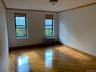Empty room featuring plenty of natural light, ornamental molding, light wood-style flooring, and radiator heating unit