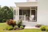 Doorway to property with covered porch and a yard