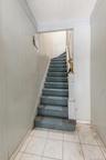Stairs with tile patterned flooring and wood walls