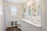 Gorgeous Hallway Bathroom with double vanity, built in shelving, wainscotting and tub.