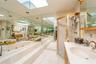 Bathroom featuring a skylight, a jetted tub, a shower stall, and vanity