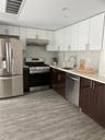 Kitchen with appliances with stainless steel finishes, white cabinets, tasteful backsplash, modern cabinets, and range hood