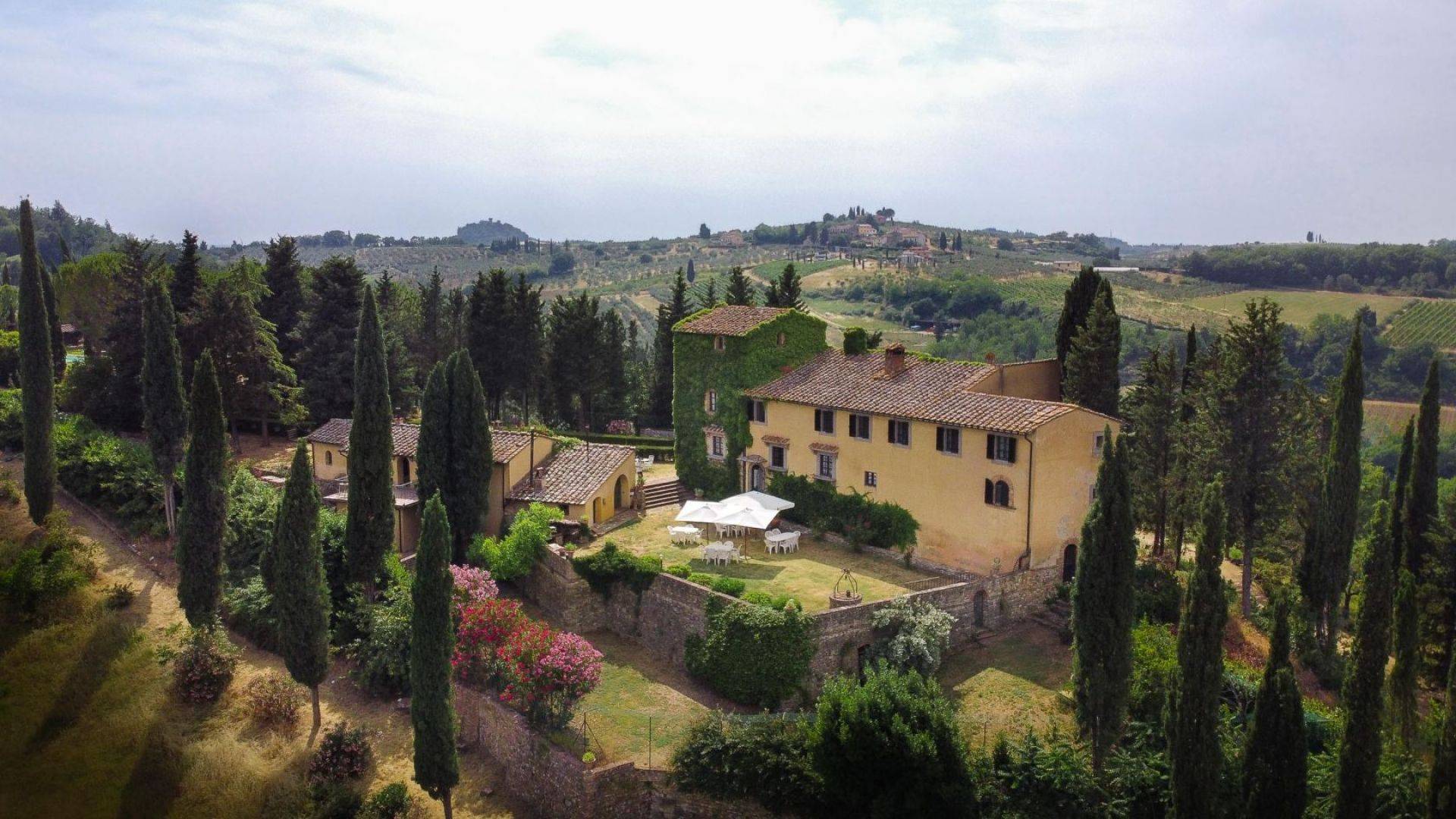 Chianti 13th-century former convent with Italian-style garden, turret, pool and land for sale south of Florence, in Tavernelle Val di Pesa.